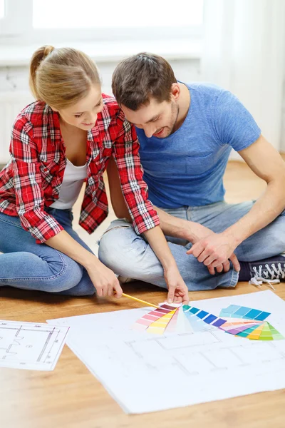 Smiling couple looking at color samples at home — Stock Photo, Image