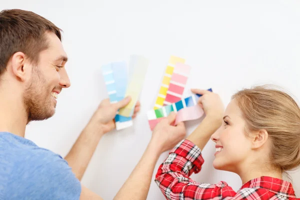 Lachende paar kleur monsters thuis kijken — Stockfoto