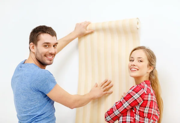 Pareja sonriente eligiendo fondo de pantalla para un nuevo hogar — Foto de Stock