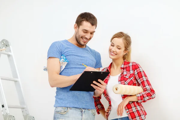 Coppia sorridente con appunti e rotolo di carta da parati — Foto Stock