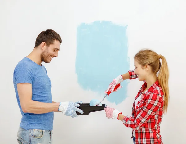 Couple souriant mur de peinture à la maison — Photo