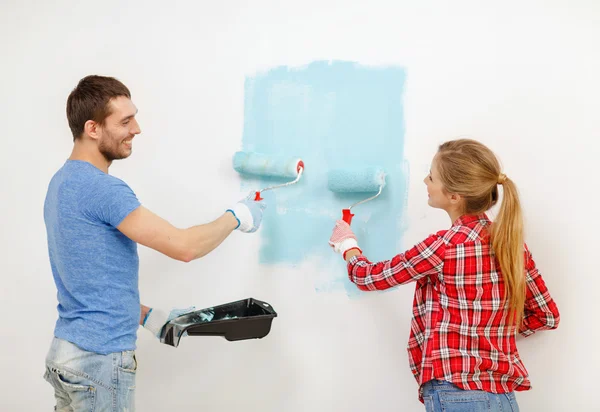 Sorrindo parede casal pintura em casa — Fotografia de Stock