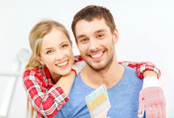 Pareja sonriente cubierta de pintura con pincel —  Fotos de Stock