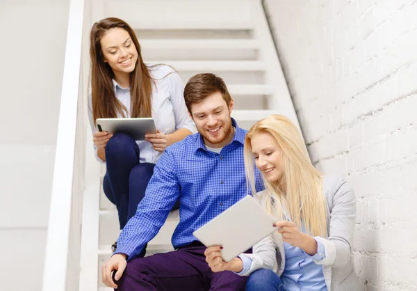 Команда с планшетным компьютером сидит на лестнице — стоковое фото