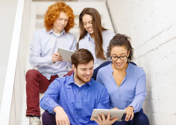 Team mit Tablet-PC sitzt im Treppenhaus — Stockfoto