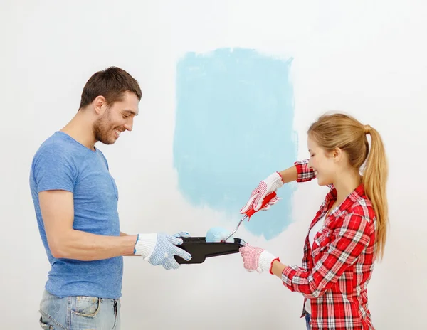 Couple souriant mur de peinture à la maison Images De Stock Libres De Droits