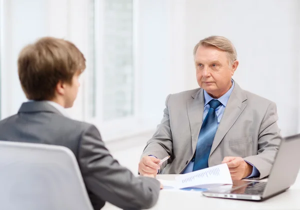 Äldre man och ung man ha möte i office — Stockfoto