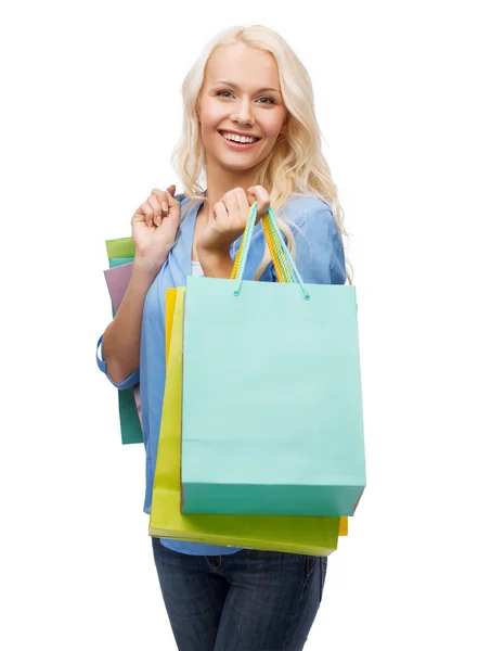 Mulher sorridente com muitos sacos de compras — Fotografia de Stock