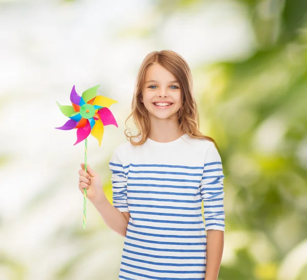 Criança sorridente com brinquedo colorido de moinho de vento — Fotografia de Stock