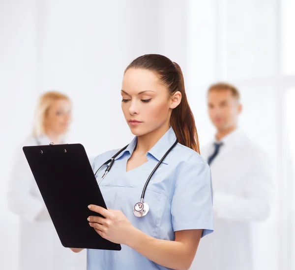 严重的女医生或护士用听诊器 — 图库照片