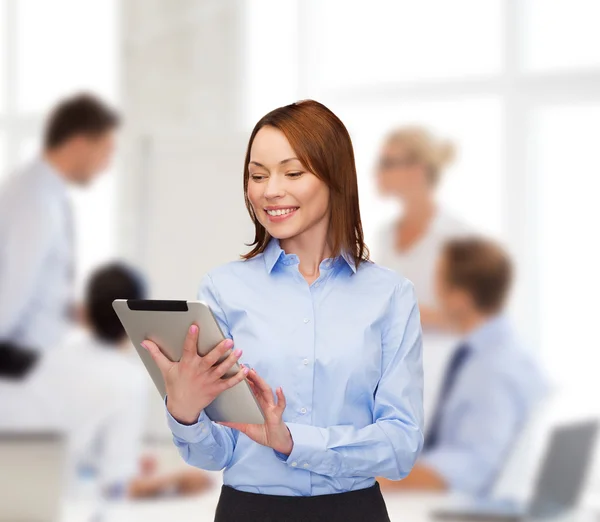 Femme souriante regardant tablette PC au bureau — Photo