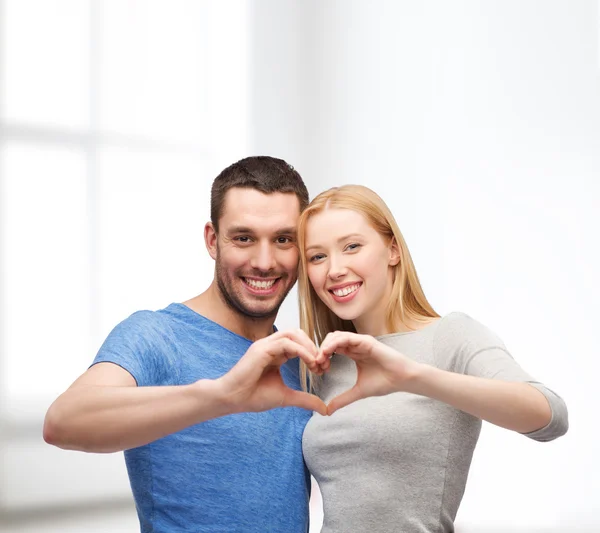 Smiling couple showing heart with hands — Stok fotoğraf