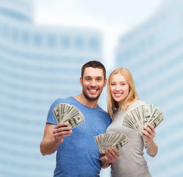 Sorrindo casal segurando dinheiro em dinheiro dólar — Fotografia de Stock