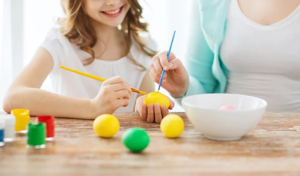 Primo piano di bambina e madre che colorano le uova — Foto Stock