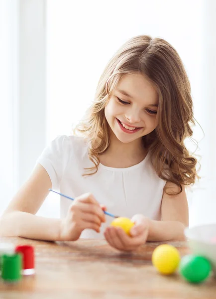 Sorridente bambina colorare le uova per Pasqua — Foto Stock
