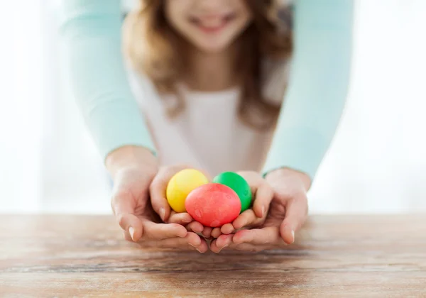 Close up of girl and mother holding colored eggs — Stock Photo, Image