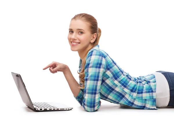 Smiling woman with laptop and pointing finger — Stock Photo, Image