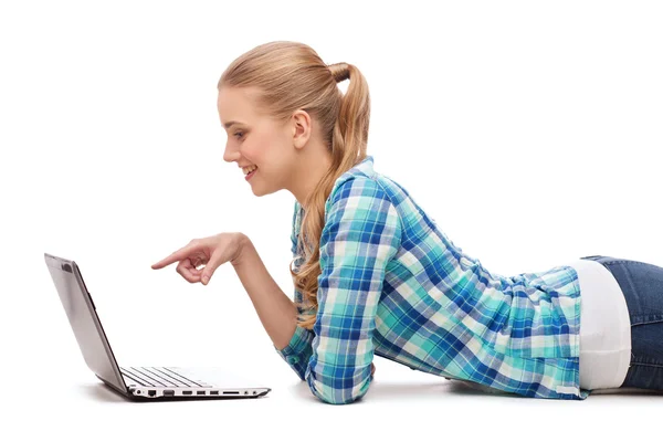 Smiling woman with laptop and pointing finger — Stock Photo, Image