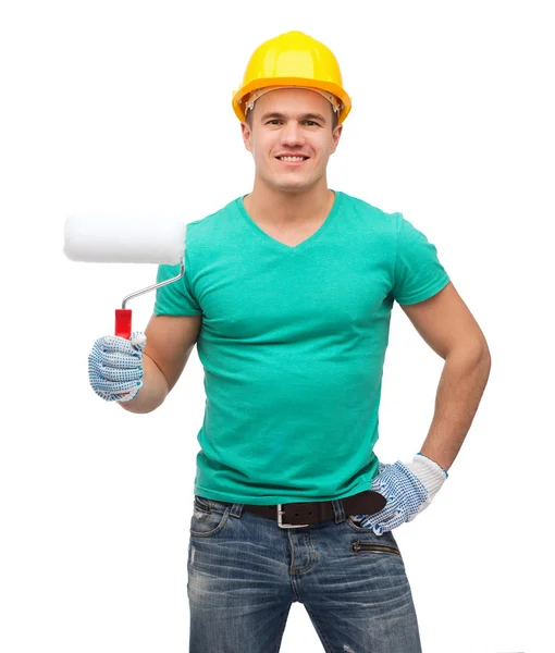 Trabajador manual sonriente en casco con rodillo de pintura —  Fotos de Stock