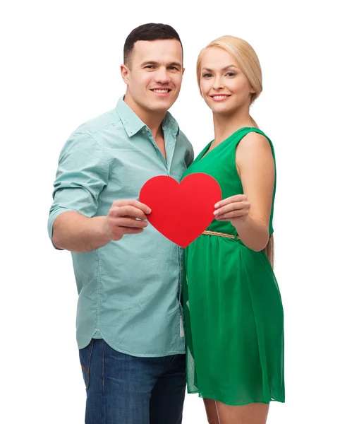 Sonriente pareja sosteniendo gran corazón rojo — Foto de Stock