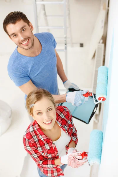 Sorrindo parede casal pintura em casa — Fotografia de Stock