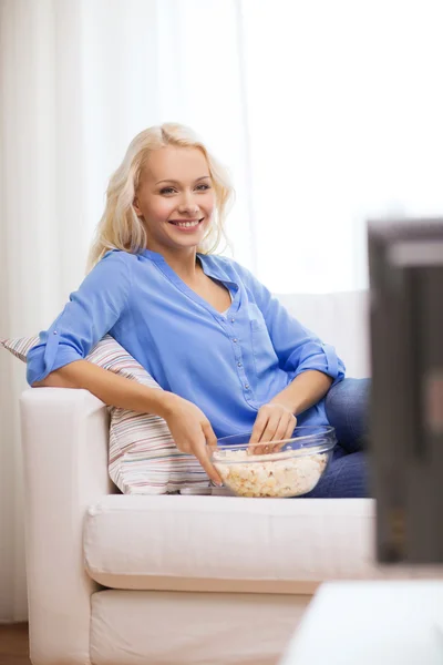 Chica joven con palomitas de maíz viendo la película en casa — Foto de Stock