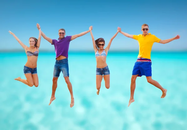 Gruppo di amici o coppie che saltano sulla spiaggia — Foto Stock