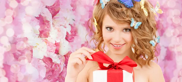 Adolescente con mariposas en el pelo regalo de apertura — Foto de Stock