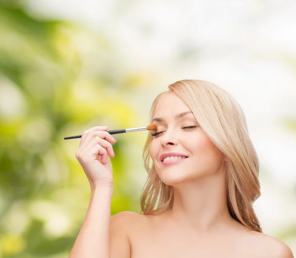 Belle femme avec les yeux fermés et brosse de maquillage — Photo