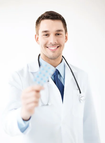 Jonge mannelijke arts met pak pillen — Stockfoto