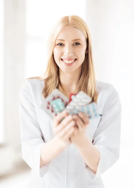 Junge Ärztin mit Packung Pillen — Stockfoto