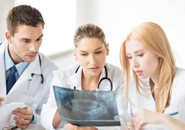 Junge Ärztegruppe schaut sich Röntgenbild an — Stockfoto