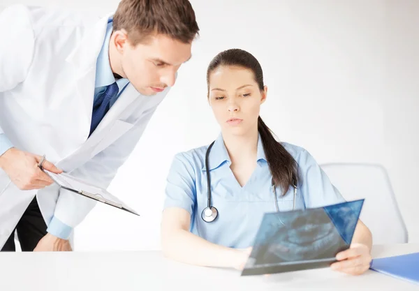 Two medical workers looking at x-ray — Stock Photo, Image