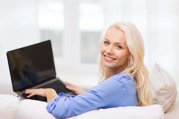 Mulher sorridente com computador portátil em casa — Fotografia de Stock