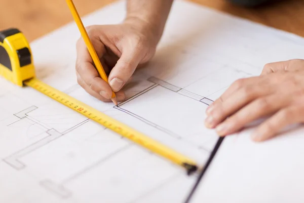 Close up of male hands making changes to blueprint — Stock Photo, Image