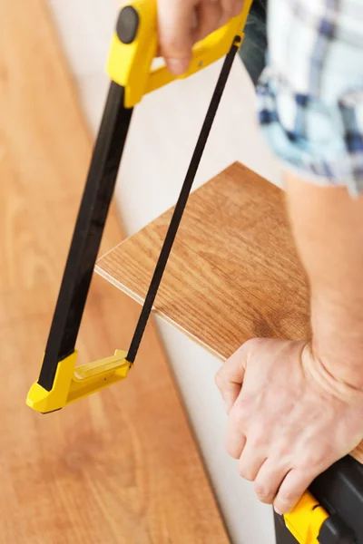 Close up of male hands cutting parquet floor board — Stock Photo, Image