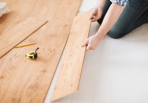 Close up van mannelijke handen intalling houten vloeren — Stockfoto