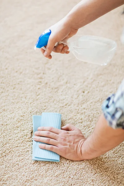 Fechar a mancha de limpeza masculina no tapete — Fotografia de Stock