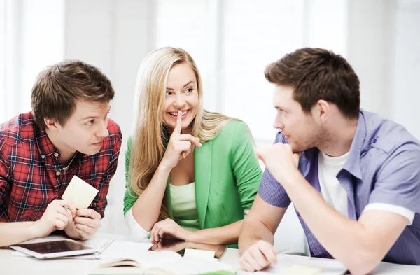 Groep studenten roddelen op school — Stockfoto