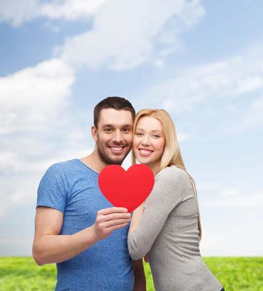 Sorridente coppia tenendo grande cuore rosso — Foto Stock