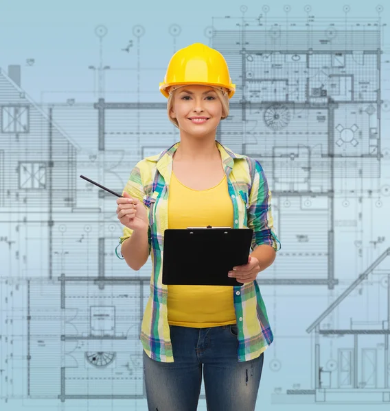 Smiling woman in helmet with clipboard — Stock Photo, Image