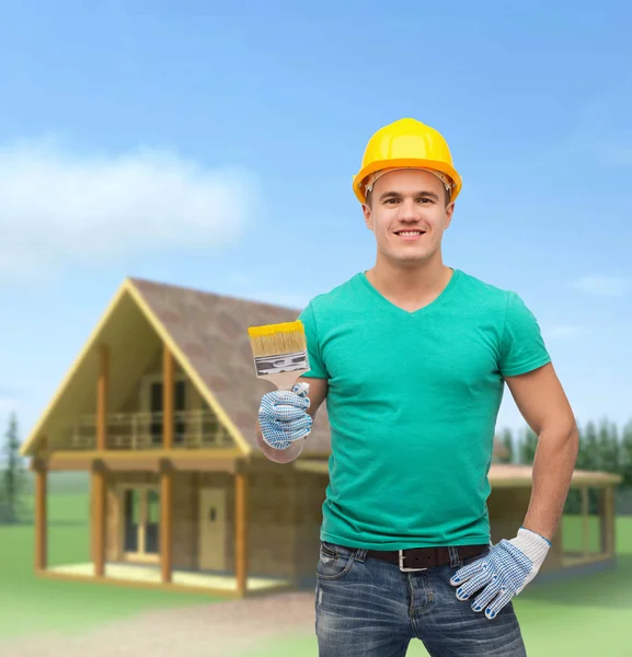 Trabajador manual sonriente en casco con pincel — Foto de Stock