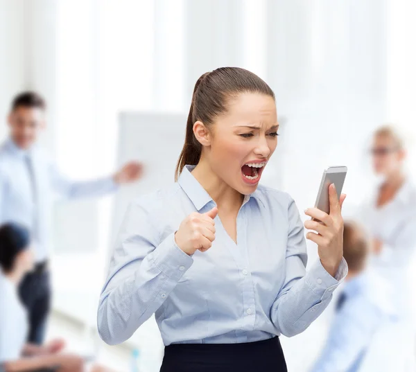 Кричащая деловая женщина со смартфоном — стоковое фото