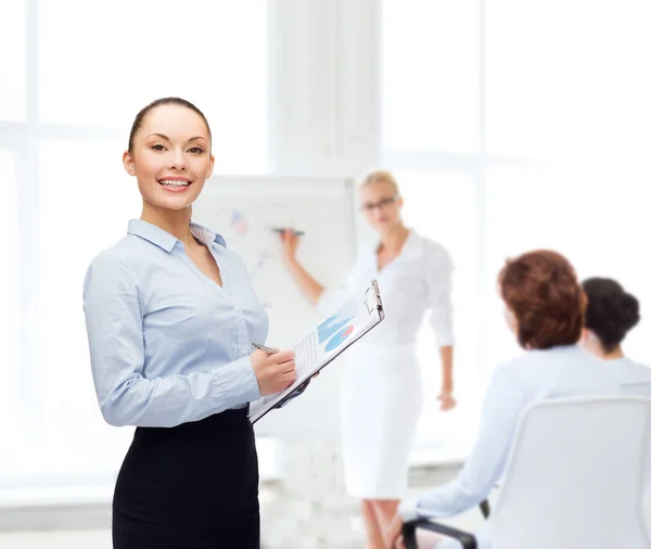 Junge lächelnde Geschäftsfrau mit Klemmbrett und Stift — Stockfoto