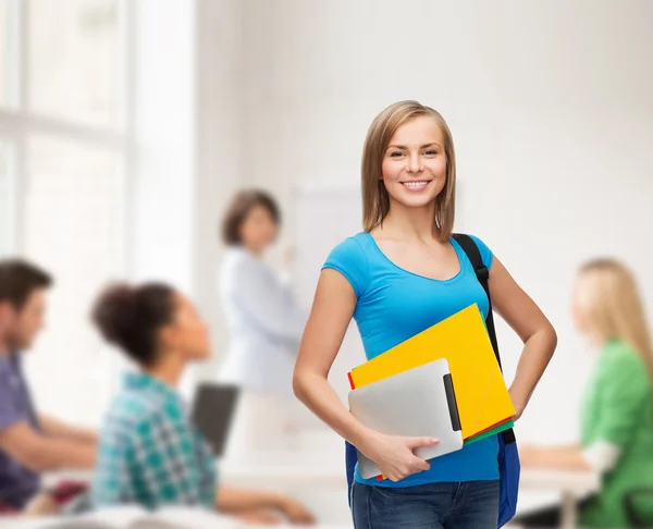 Estudiante sonriente con bolsa, carpetas y tableta pc — Foto de Stock