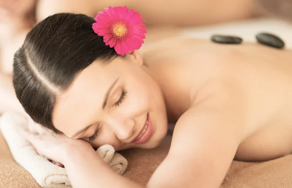 Femme au spa avec des pierres chaudes — Photo