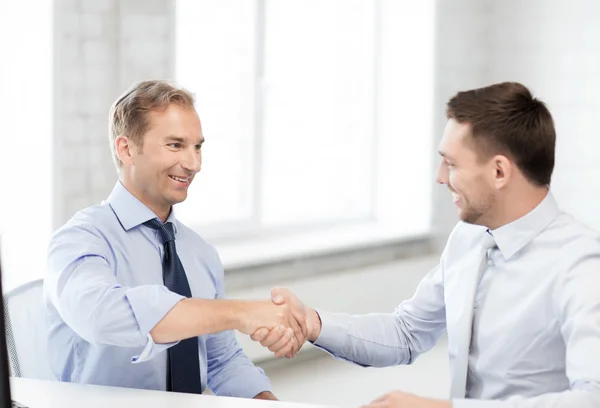 Businessmen shaking hands in office — Stock Photo, Image