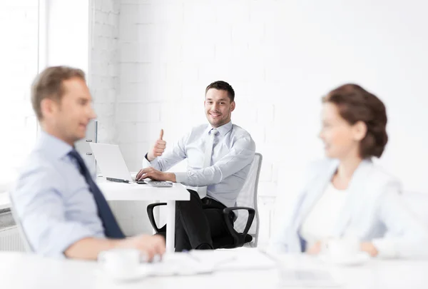 Feliz hombre de negocios mostrando pulgares hacia arriba en la oficina — Foto de Stock