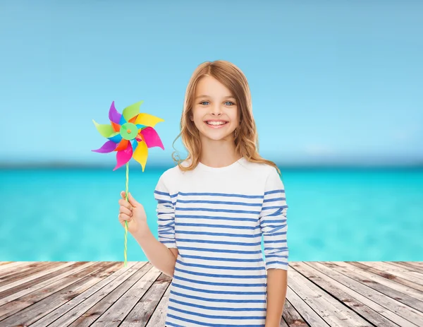 Enfant souriant avec jouet moulin à vent coloré — Photo