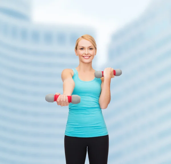 Jovem mulher esportiva com halteres leves — Fotografia de Stock